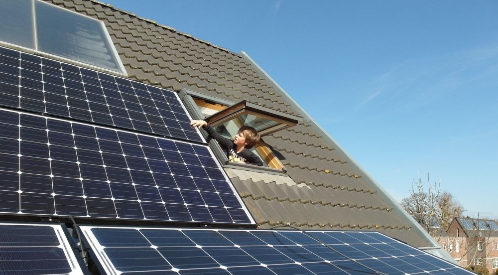 Zonnepanelen op dak met kind in dakraam